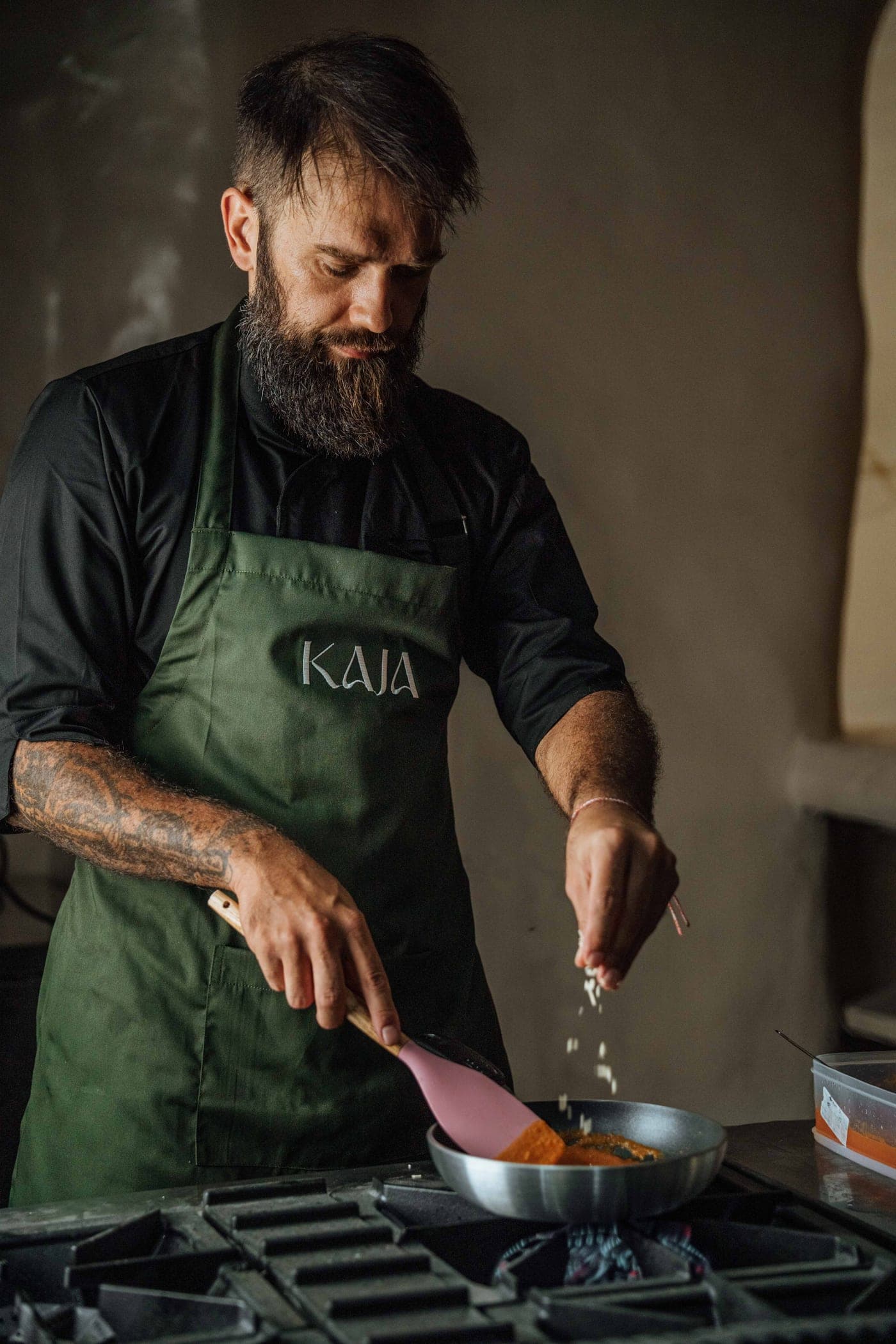 KAJA's chef cooking at the stove in a KAJA apron